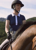 Person riding a horse with a scenic background of mountains and greenery